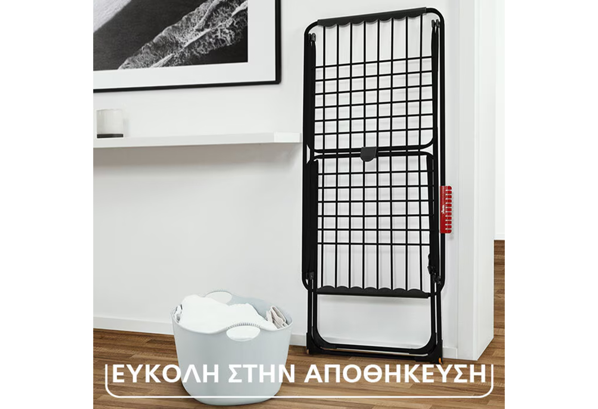 Απεικονίζεται η απλώστρα διπλωμένη και στηριγμένη σε έναν τοίχο.